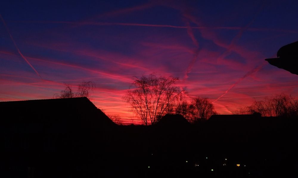 Sunset with red lit contrails