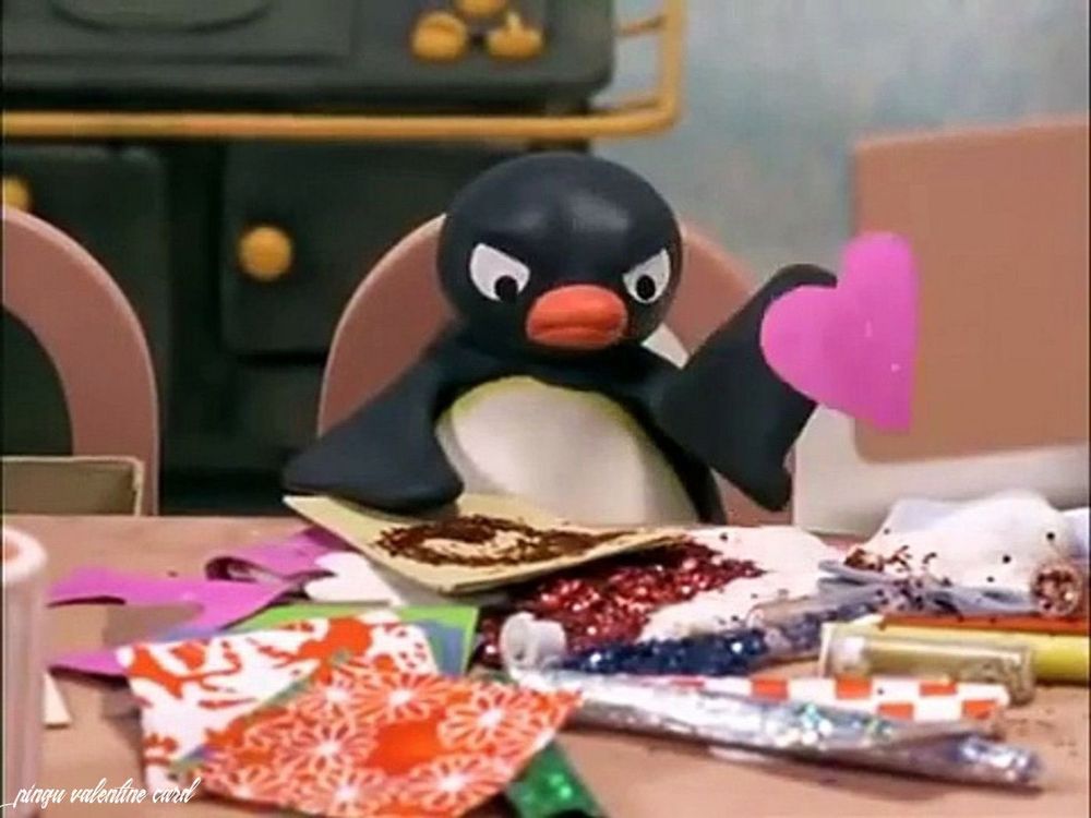 Angry penguin puts a cut out heart on top of their glitter art.