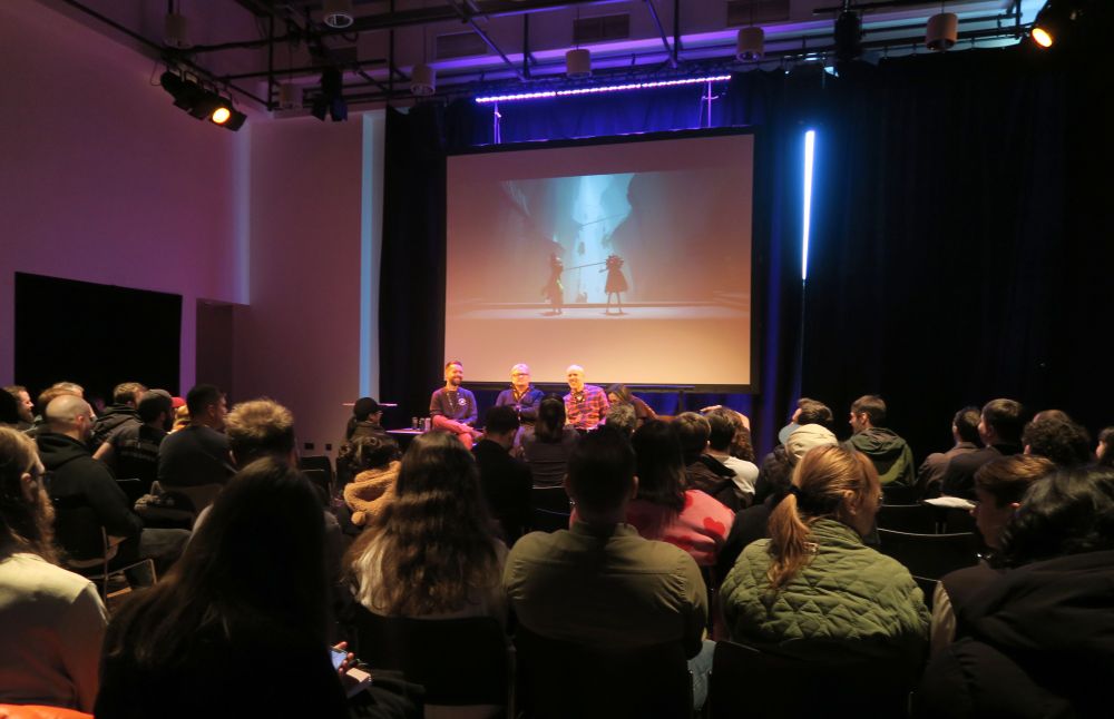 Two point studios talk, photo taken from the back of the audience looking over a full room. 