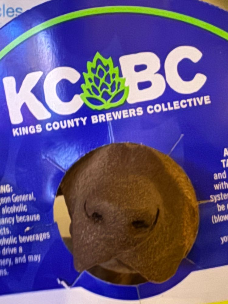 The nose of a fake dog poking through a keg collar.