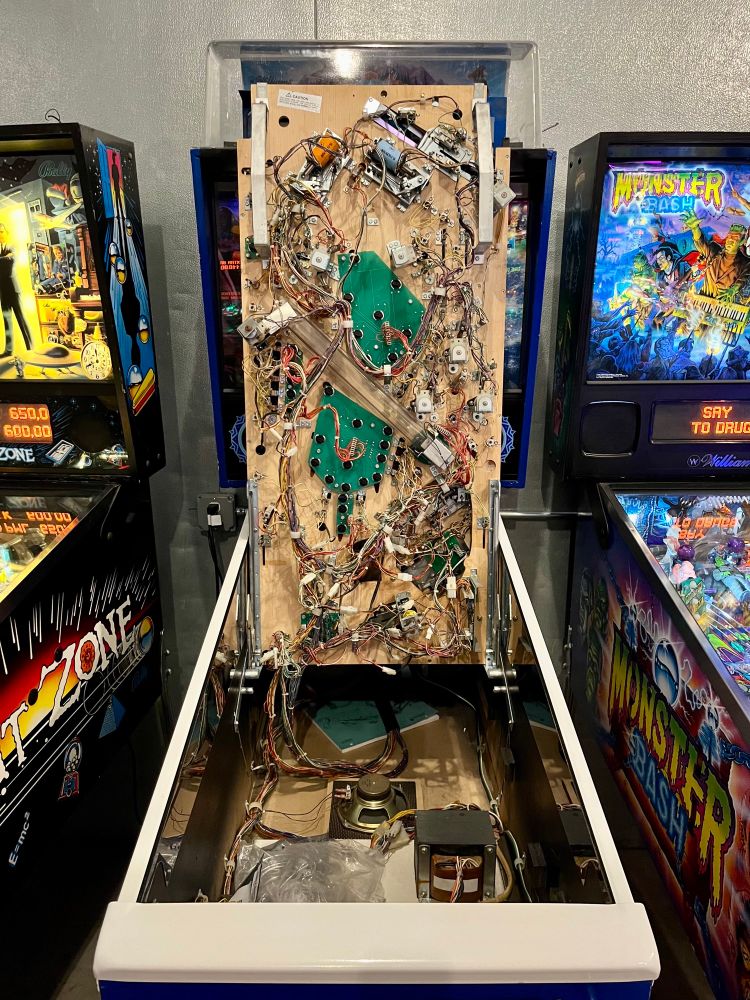 The underside of a pinball playfield, full of wires, coils, flux capacitors, etc.