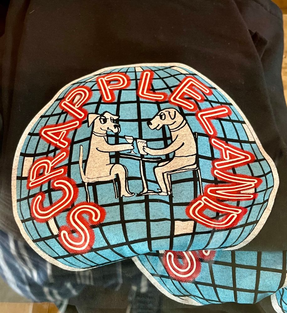 New Scrappleland T-shirts! The logo is a disco ball with two dogs sitting at a table and enjoying a beer.