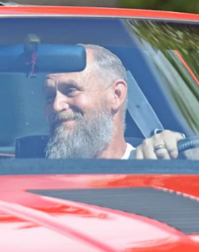 a balding bearded man driving a red camri (from Vince Panaro pap images)