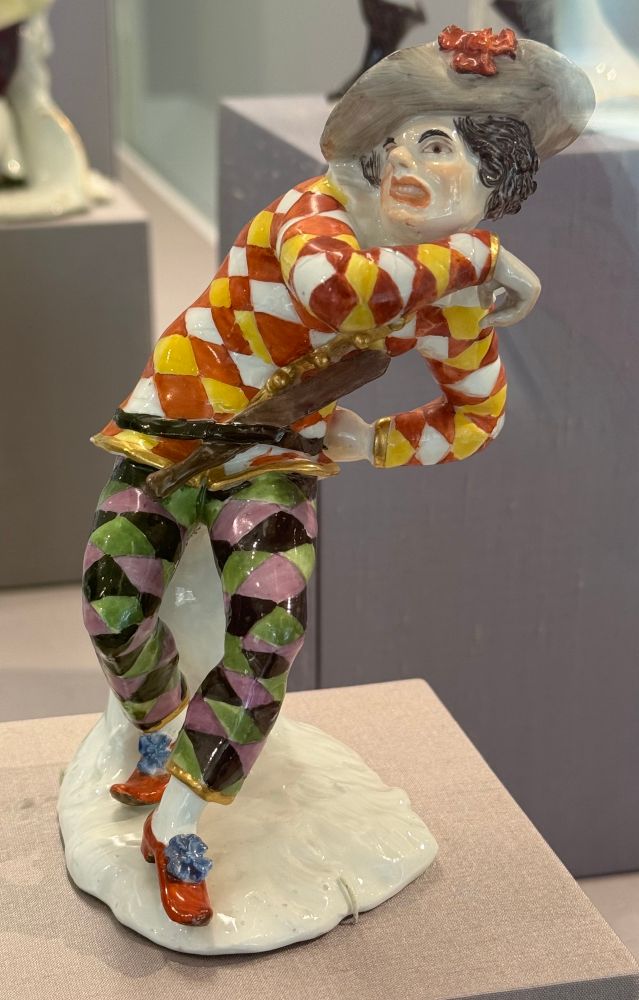 A porcelain jester figure having a negative emotion 