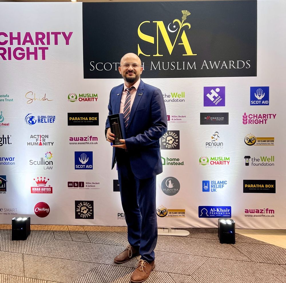 Qammer Abbasi holding the award
