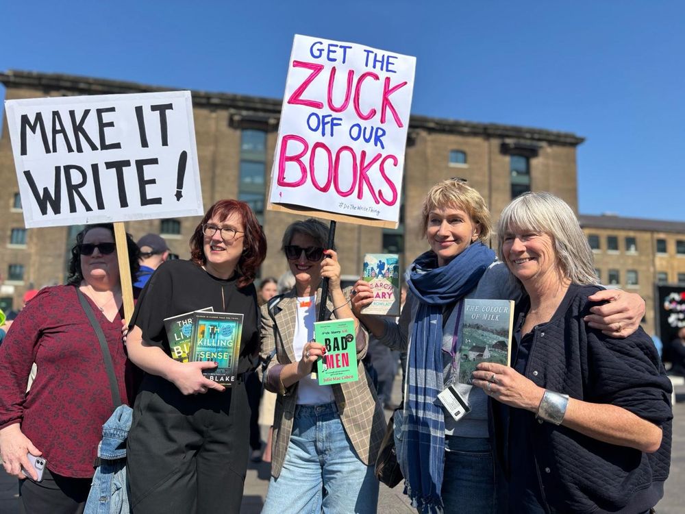 Brilliant placards from the authors gathering in Granary Square. 5 authors under a bright blue sky including Sam Blake, Julie Cohen, Bee Rowlett and Nell Leyson. Placards read Make it Write and Get the Zuck off our Books. Authors are holding their books
