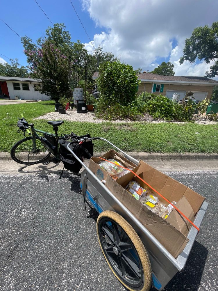 The Hard Water e-bike pulling a trailer loaded with salads and sandwiches.

Chaos garden in the background 