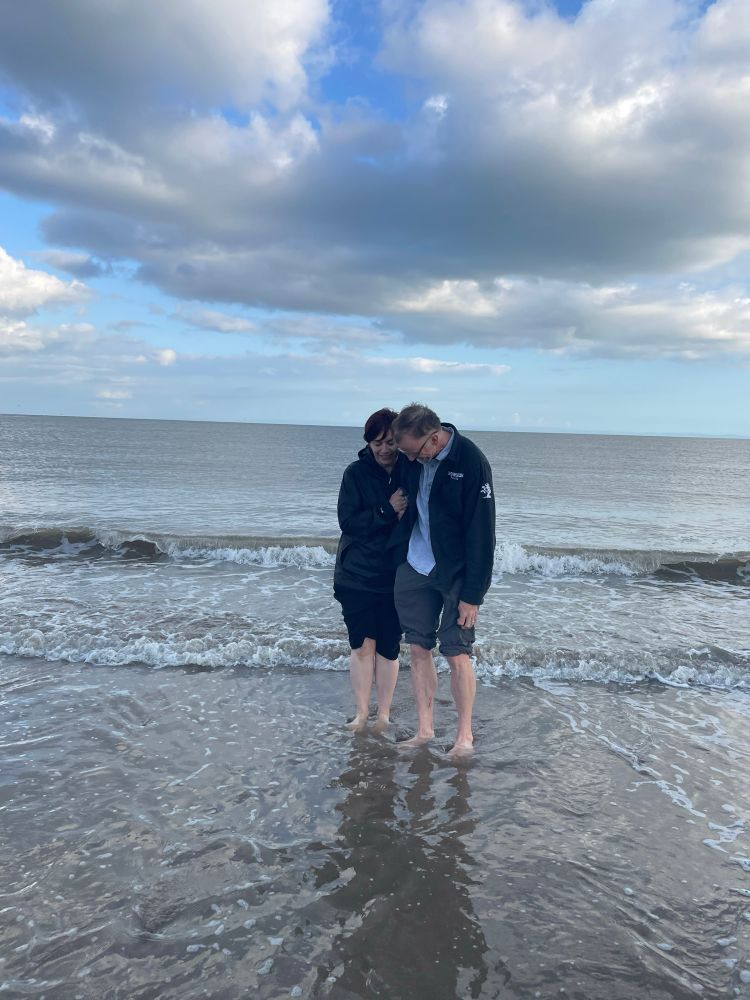 A man and woman standing in the surf 