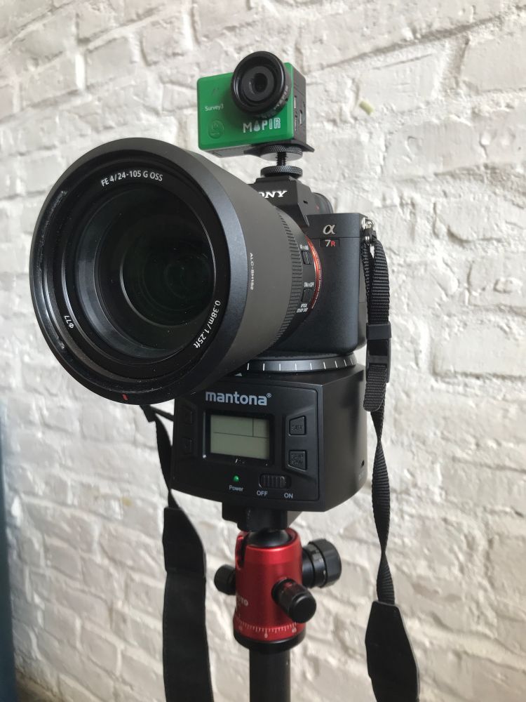 Tripod head with timelapse motor, Sony DSLR, and GoPro style drone camera all stacked vertically on top of one another  