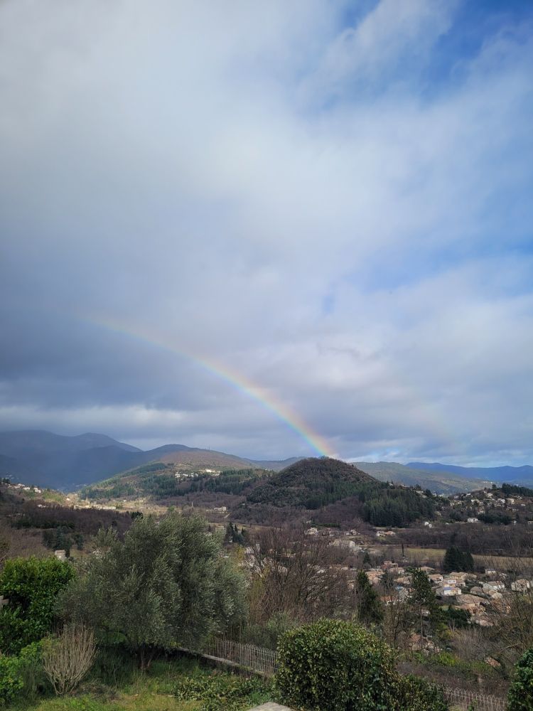 Photo d'une vallée avec un arc en ciel