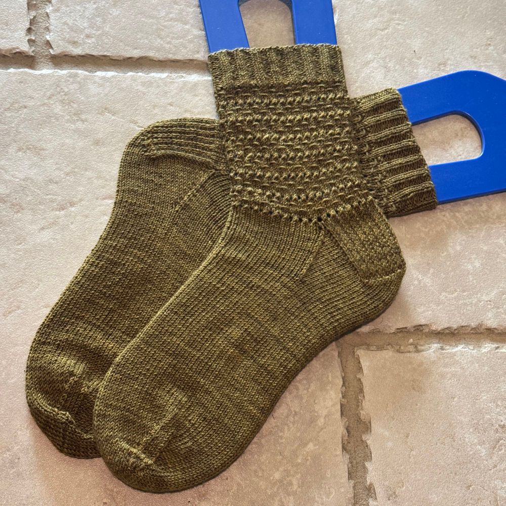 Dark green socks on a tile floor