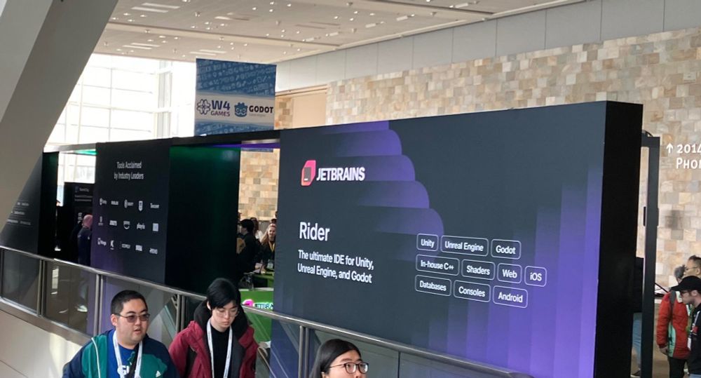 Moscone West lobby. A large Jetbrains Rider display mentions Godot support as a feature. In the background is a banner saying “W4 Games / Godot”.