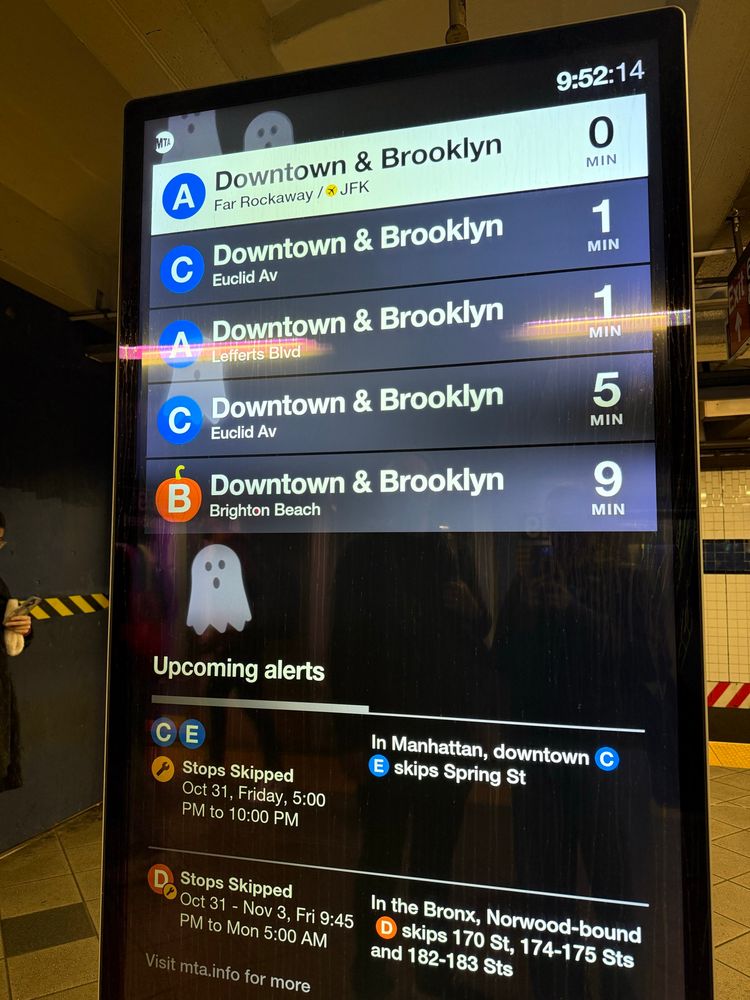 Subway alert sign with ghosts floating in the background, the orange B is shaped as a pumpkin