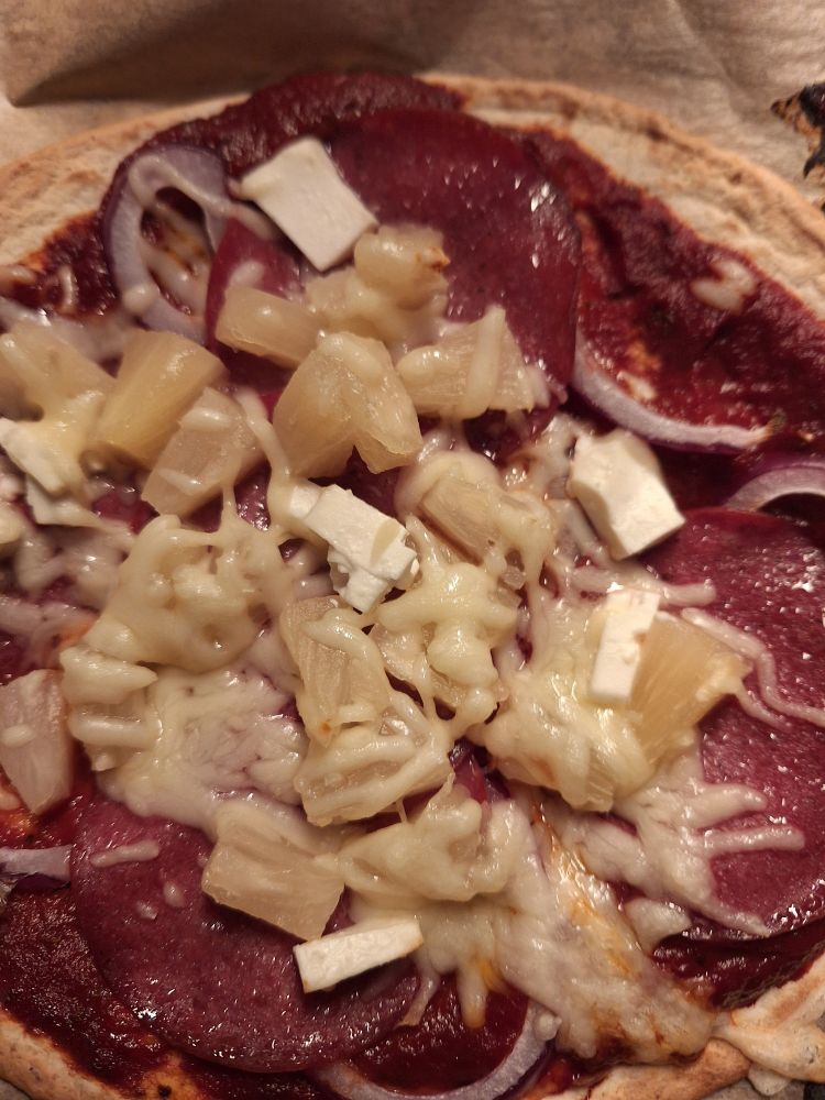 Fladenpizza mit Salami, Zwiebeln, Feta, Pizzakäse und Ananas