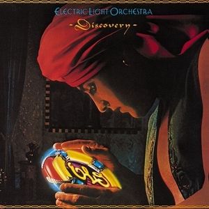 A man bends over a glowing disk emblazoned with the Electric Light Orchestra logo