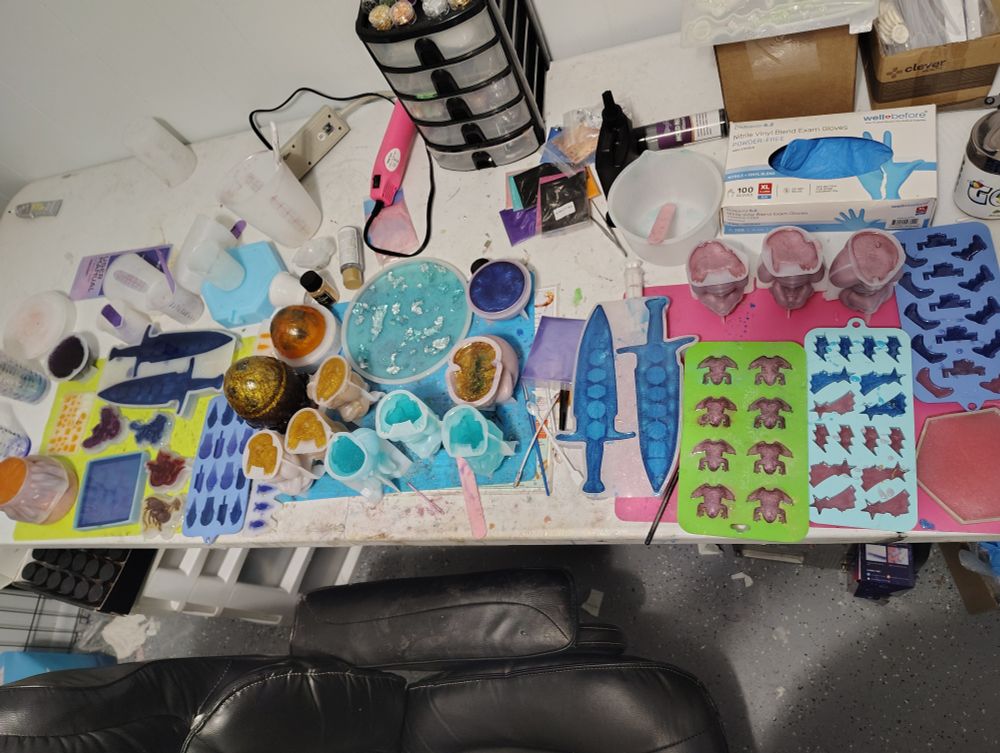 A table of various silicone molds with epoxy resin of different colors.