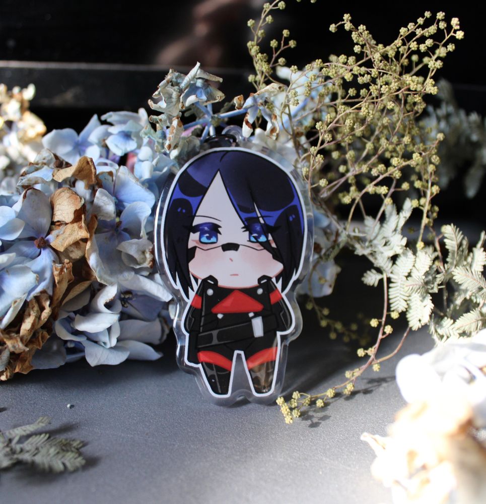 Elster keychain surrounded by blue flowers and foliage