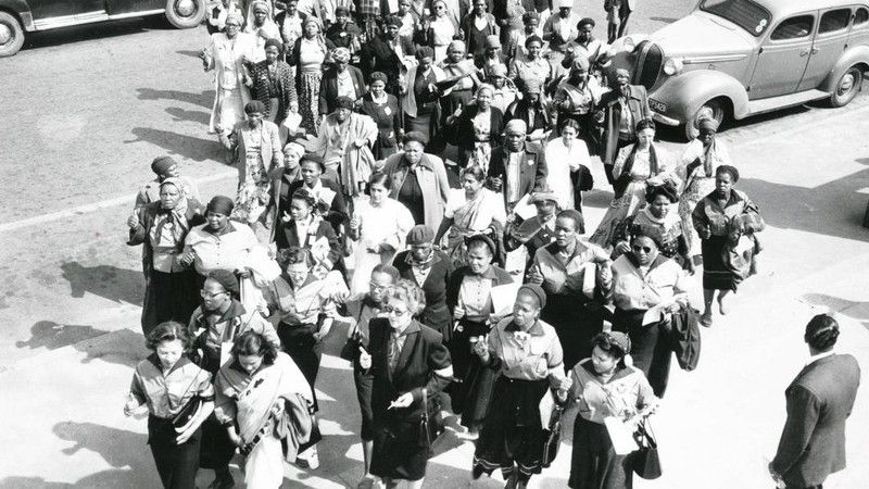 The march was led into the amphitheatre of the Union Buildings by a smaller group of women who handed the petition of demands and objections to the white supremacist apartheid prime minister of what was still a British colony (South Africa only became a republic independent of Britain on 31 May 1961); some of this smaller group pictured here includes Lillian Ngoyi, Sophia Williams-de Bruyn, Rahima Moosa, and Helen Joseph. Other women involved in leadership and organisation included Ruth Mompati, Fatima Meer (one of Mandela's earliest biographers who was imprisoned with Winnie Mandela in the prison complex whicb became post-apartheid South Africa's apex court, the Constitutional Court in Johannesburg), Albertina Sisulu, Frances Baard, Annie Peters, Nosipho Dastile, Flotence Mkhize, and the trade unionist Rita Ndzanga.