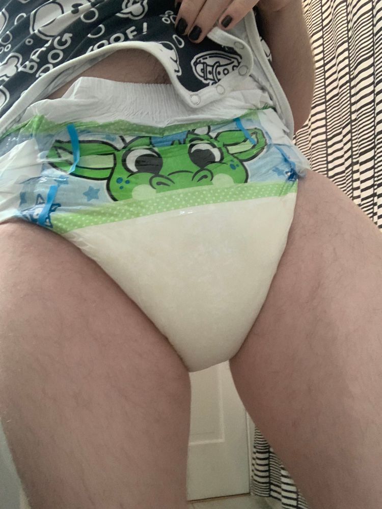 A dragon peekabu diaper, thoroughly used, and causing my thighs to spread apart just slightly