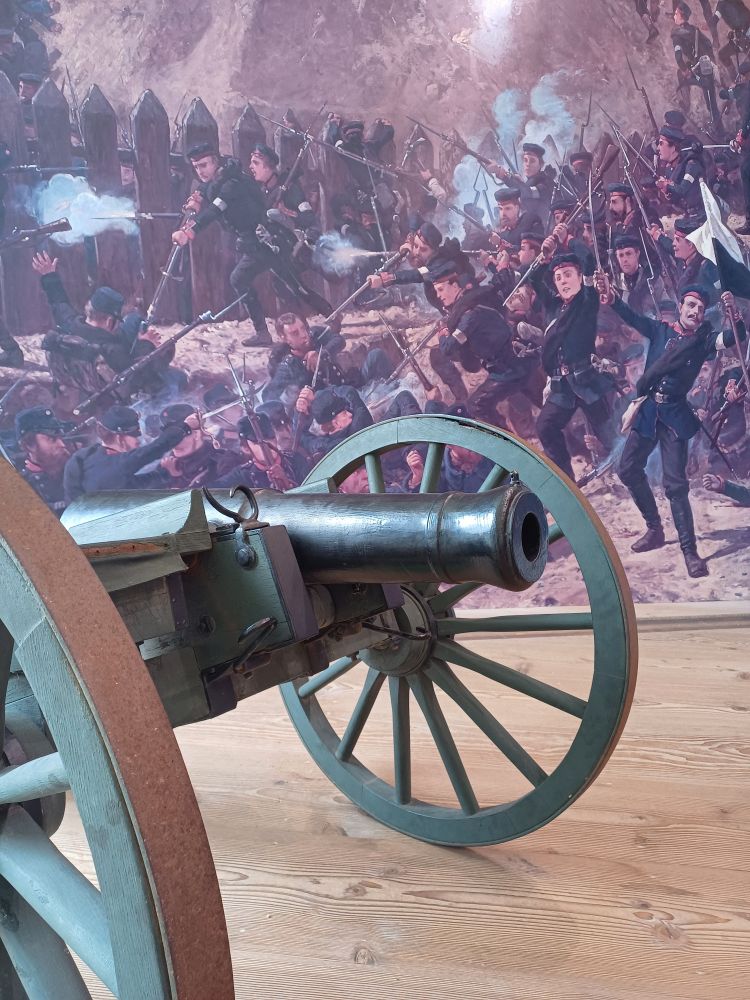 Picture of a cannon in front a photostat of a battle from the second Schleswig war 1864 by painter Fritz Schultz.

The painting is very dramatic with uniformed German troops storming a Danish fortification. Gunsmoke, stabbing with bayonets, people being shot and all the gore of war suitable for a national heroic painting.

Nothing to do with the subject I am reseaching (besides bayonets) but it was a neat exhibition at the 1864 Miseum.