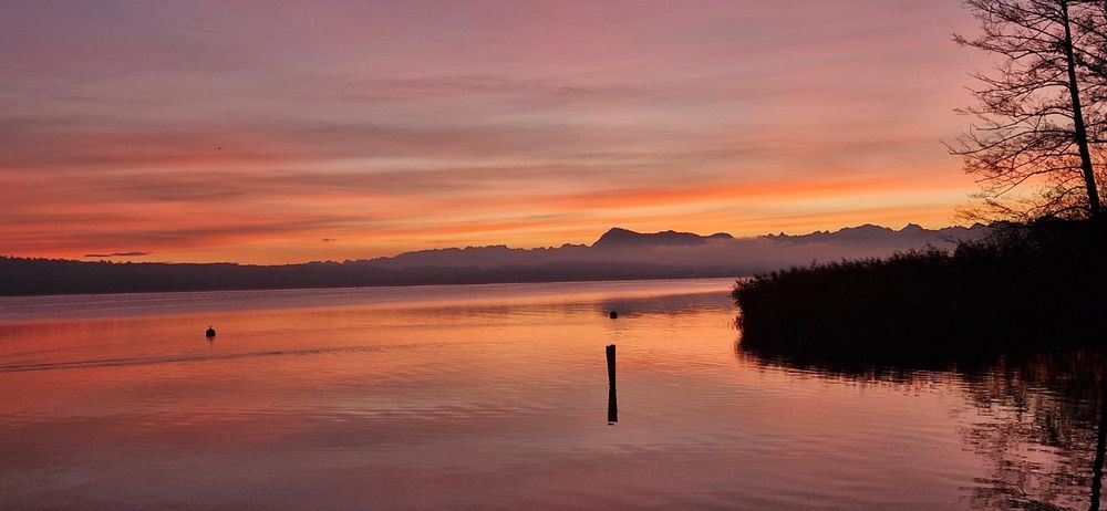 Ein Gewässer mit einem Sonnenuntergang im Hintergrund