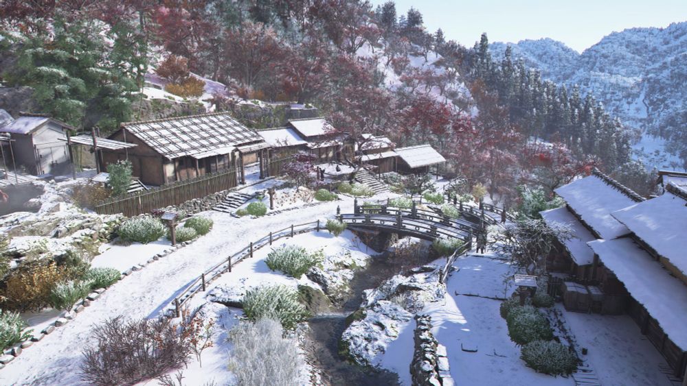 Un petit village médiéval japonais à flanc de colline, recouvert par la neige. La route principale qui le traverse est bordée par une petite rivière.