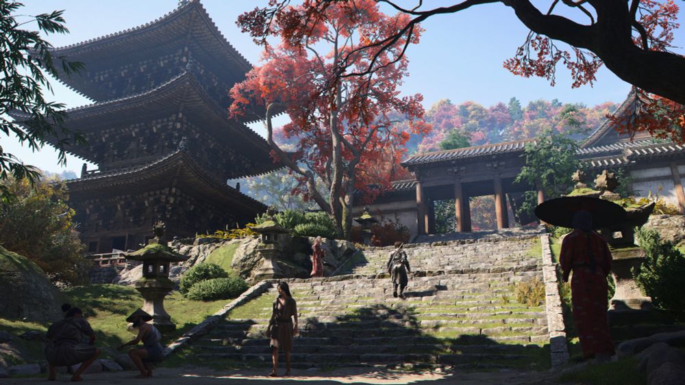 Un temple japonais. Un grand escalier large en pierre mène jusqu'à son entrée. En arrière plan, on aperçoit une grande pagode à 3 étages ainsi que de nombreux arbres aux couleurs de l'automne.