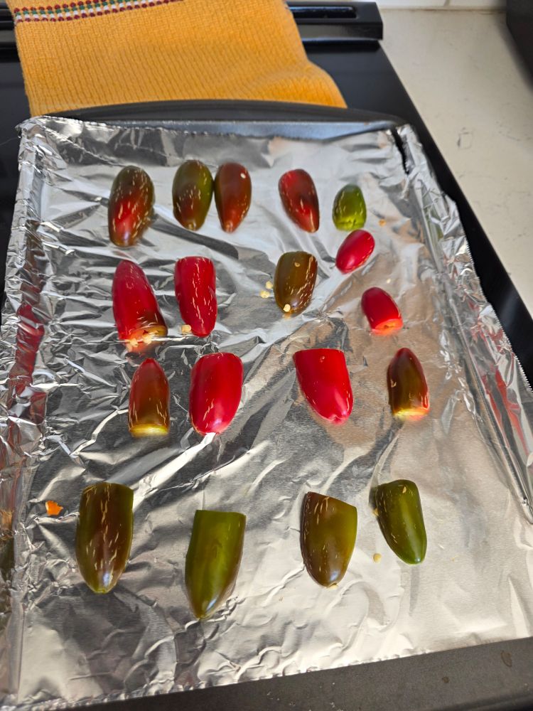 The same jalapeños on a tray, halved and de-stemmed