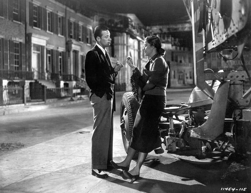 Joe Gillis (William Holden) and Betty Schaefer (Nancy Olson) standing and talking on a Paramount backlot made to look like a city street.