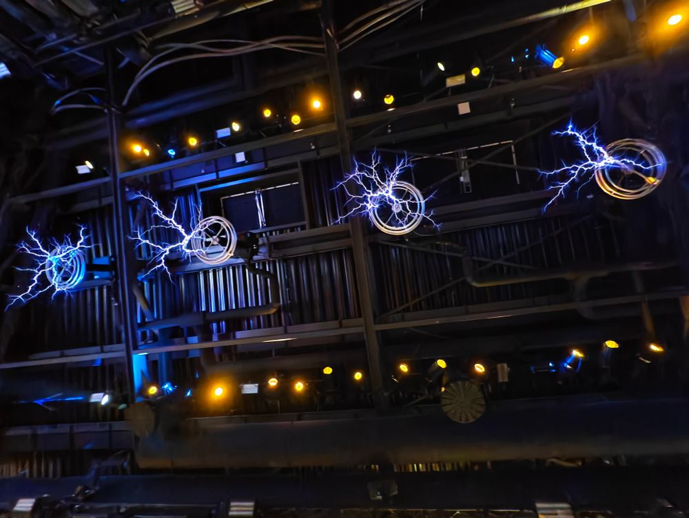 An der Decke hängende Teslaspulen im Wartebereich der Achterbahn Voltron Nevera, welche Musik spielen.