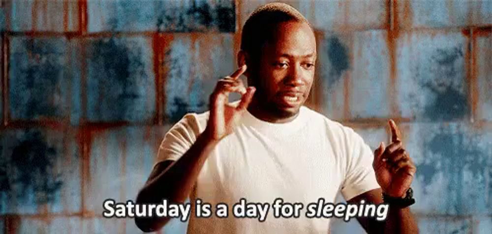 a man in a white shirt is giving a thumbs up and saying `` saturday is a day for sleeping '' .