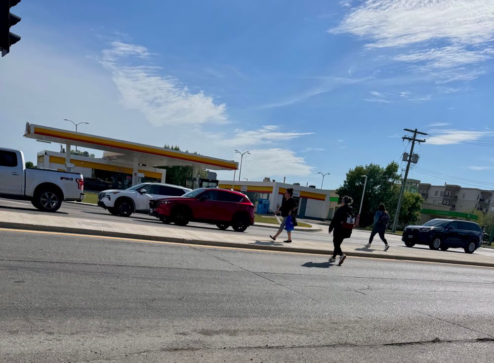 People jaywalking across the road trying not to miss their bus