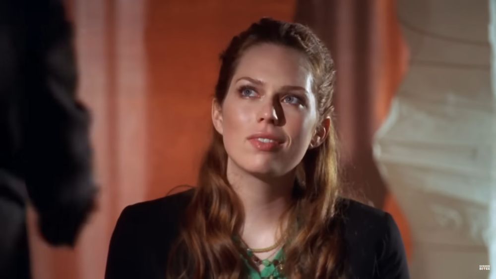 captura de tela de uma cena de house mostrando uma mulher ruiva e elegante com um olhar ligeiramente presunçoso para com seu potencial, futuro chefe indecente