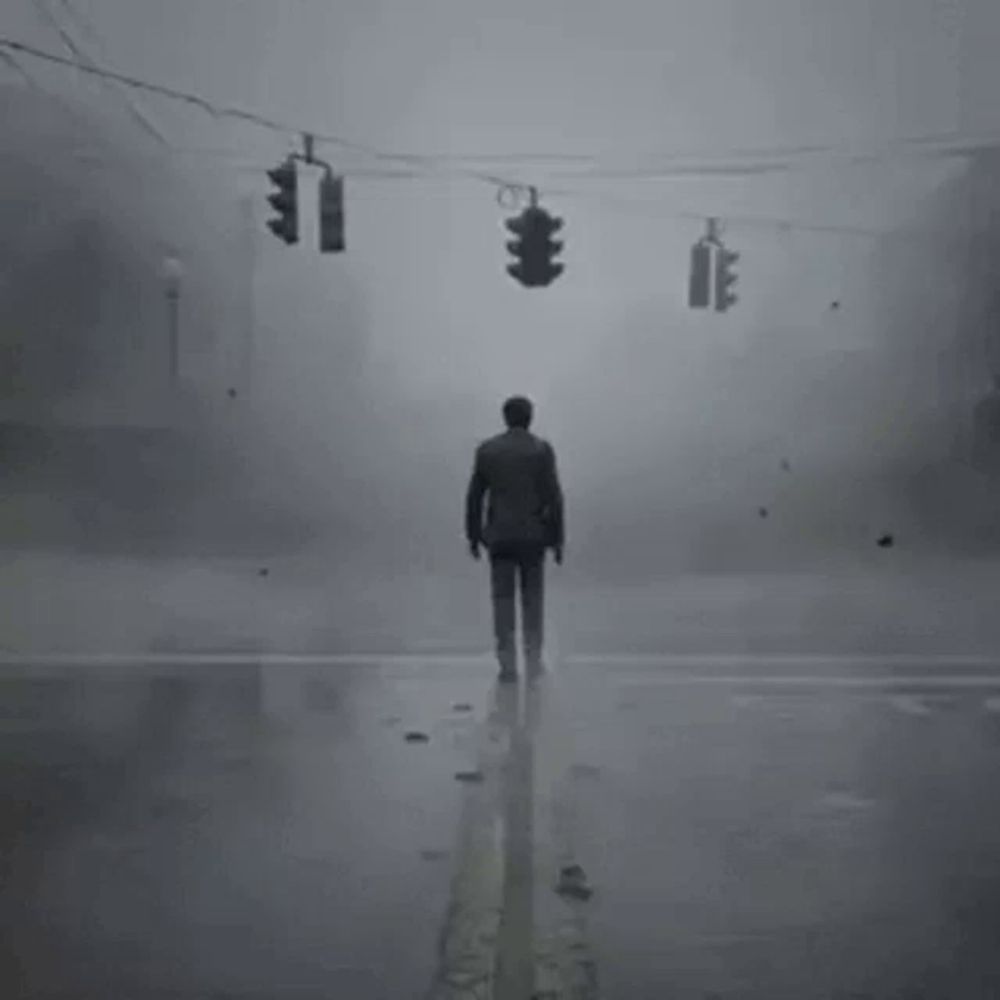 a man is standing in the middle of a foggy street .