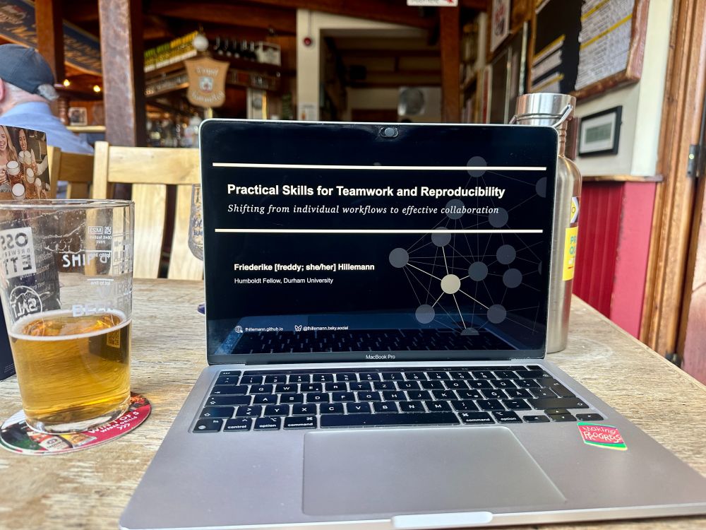 laptop a pub: presentation with title slide "Practical Skills for Teamwork and Reproducibility - Shifting from individual workflows to effective collaboration"