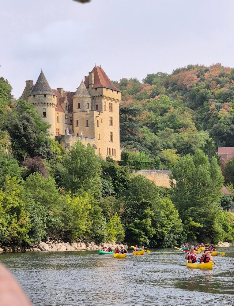 Gabarre trip down the  Dotdogne with lots of canoes and castle overlooking the river