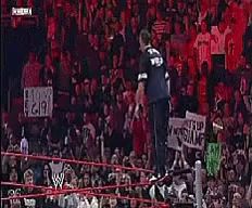 a blurry picture of a wrestling match with a w logo on the bottom right