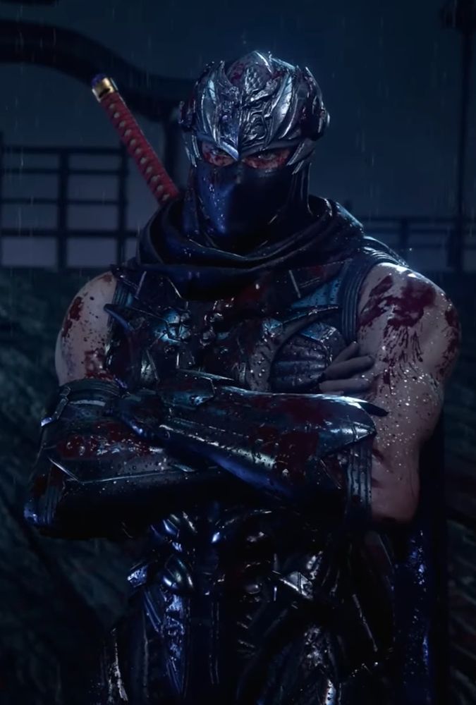 Waist-up screenshot of a bloodied Ryu Hayabusa during a cutscene in Ninja Gaiden 4. He's crossing his arms while standing in the rain, the lighting dark and gloomy.