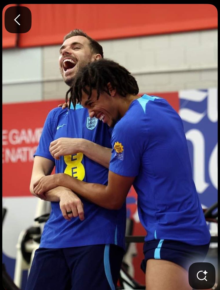 Jordan Henderson laughing while Trent Alexander-Arnold holds his arm and laughs also