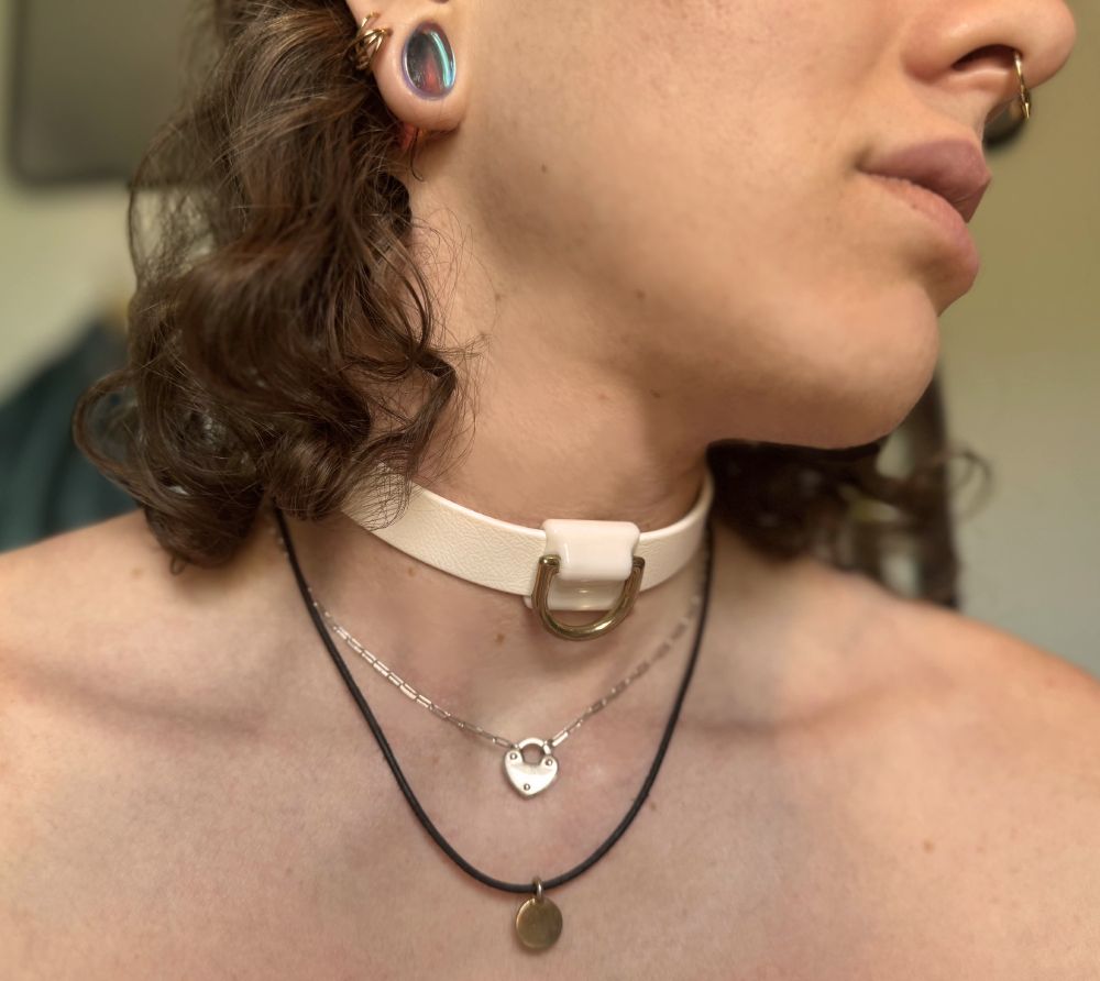 A picture of me wearing a white Biothane collar with a brass D-ring made by @beltbolt.co.uk‬