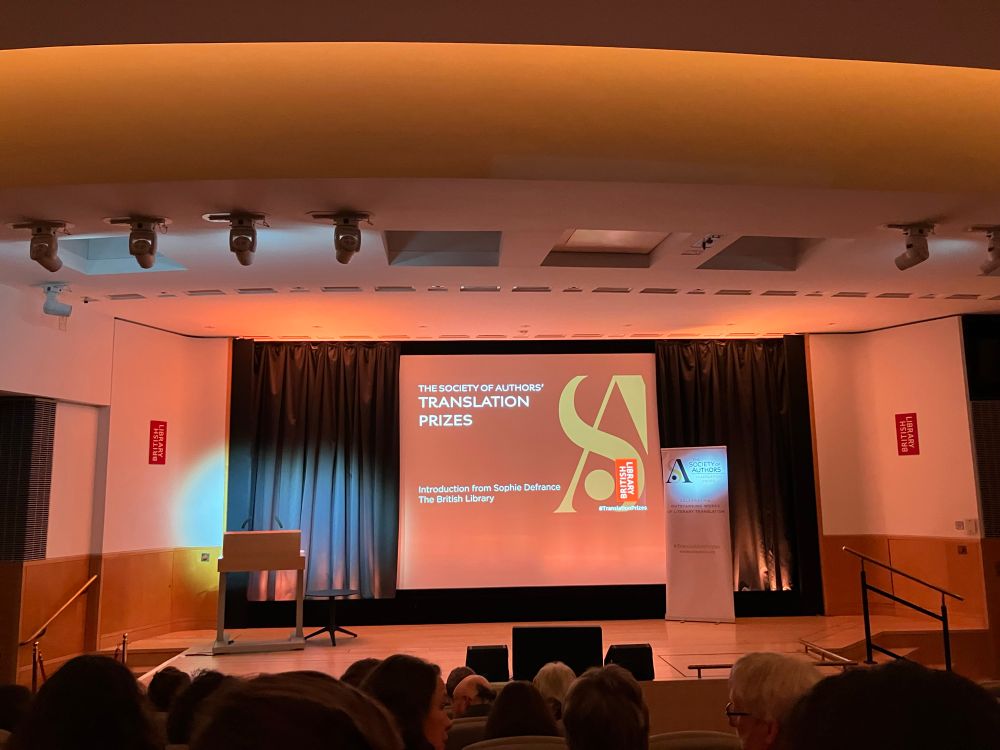 A stage in the British Library, with a screen projection announcing the SOA Translation Prizes. 