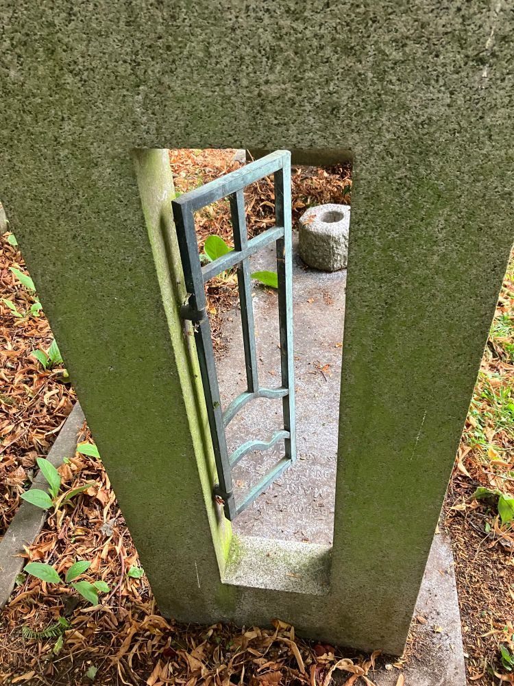 A gravestone shaped like a metal gate inside a piece of granite…
