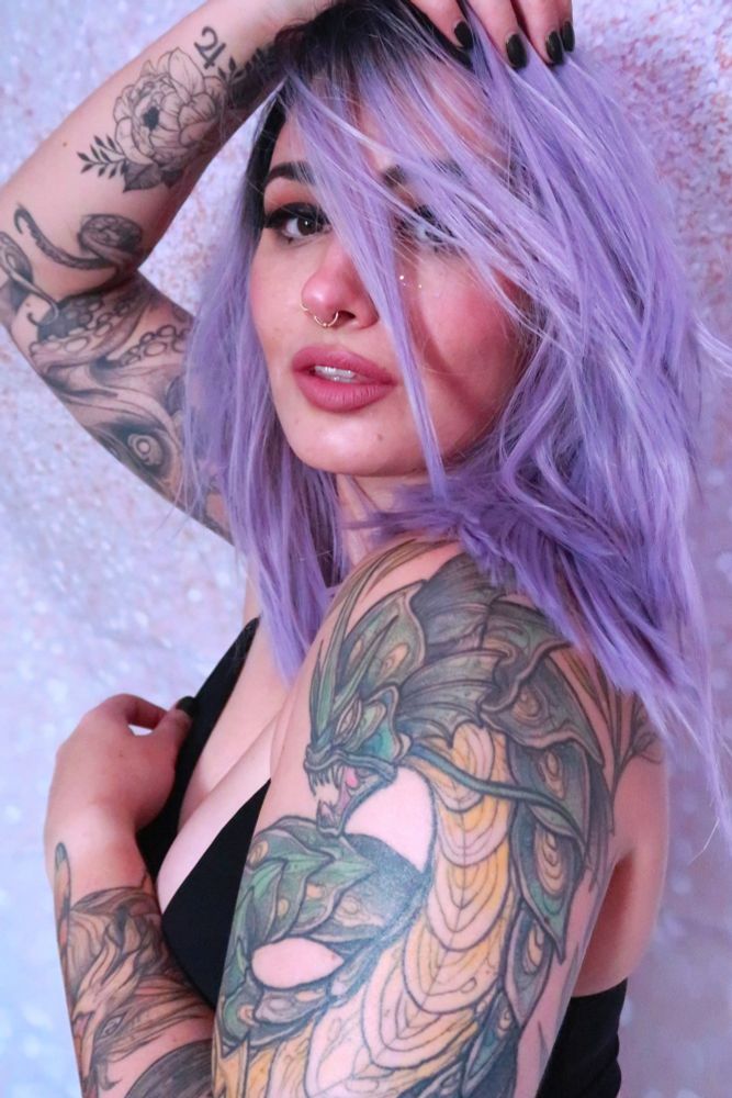 bust shot of woman in purple wig and cute makeup 