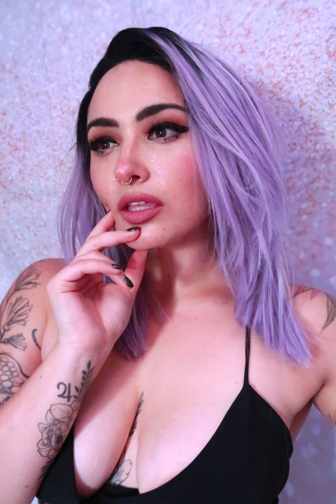 bust shot of woman in purple wig and cute makeup 