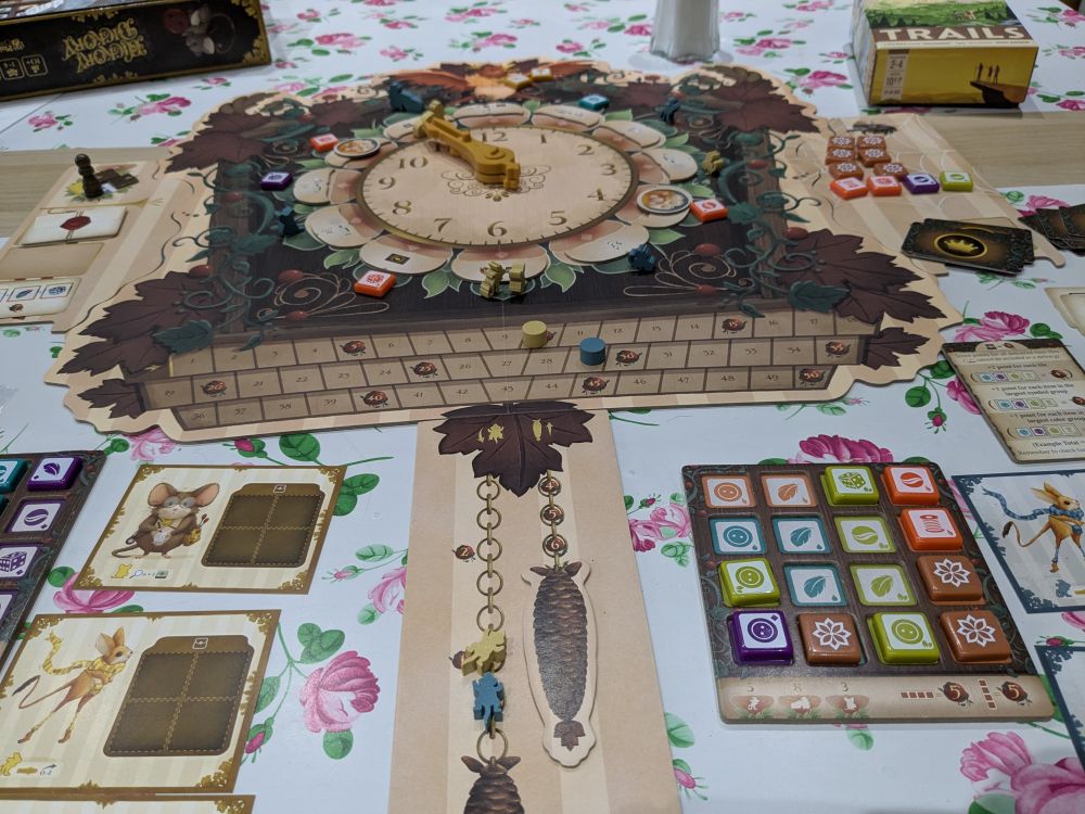 A board that looks like a coocoo clock and various colourful boardgames pieces