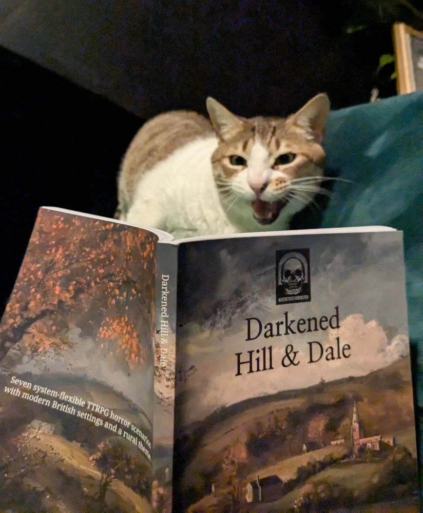 An opened copy of a book titled Darkened Hill & Dale - a cat is looking at the pages with her mouth open, as if mid scream 