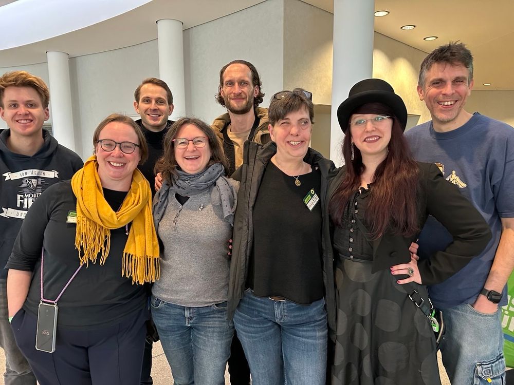 Gruppenphoto. Menschen stehen lächelnd in zwei Reihen.