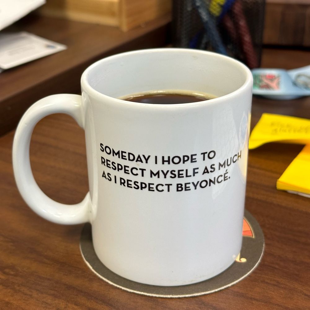 My coffee mug, which has text saying SOMEDAY I HOPE TO RESPECT MYSELF AS MUCH AS I RESPECT BEYONCE.