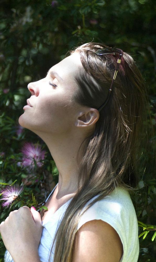 Photo of woman in profile, eyes closed, head tilted up.
