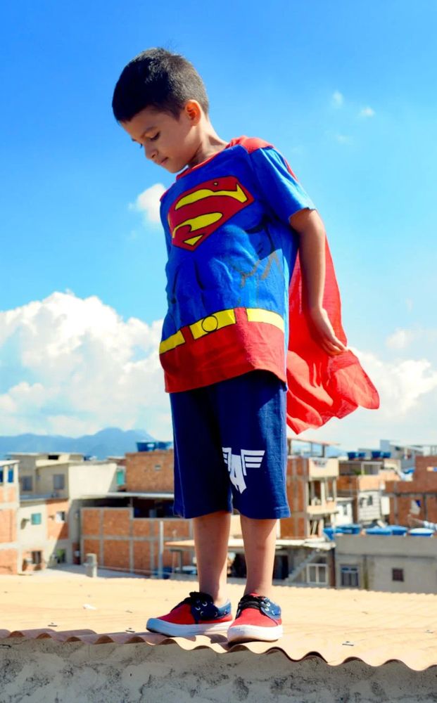 Kid wearing superman costume.